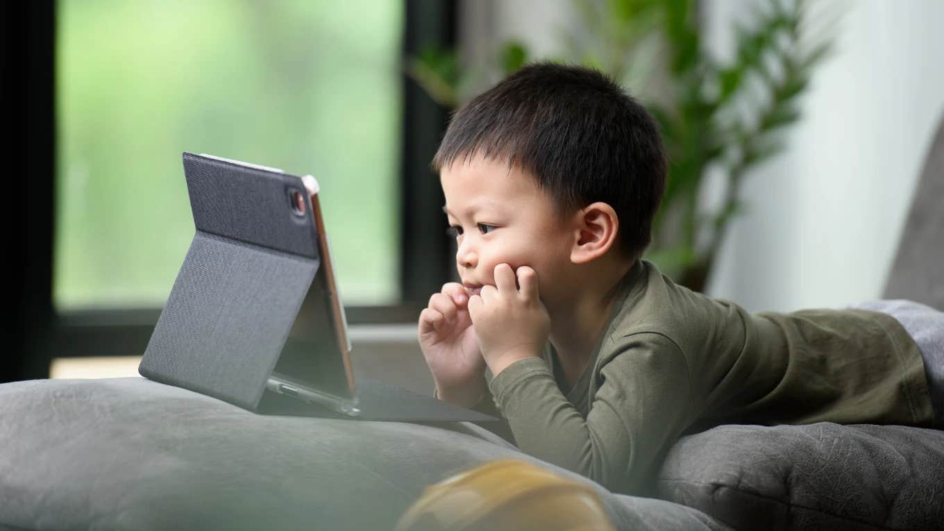 Mom Says 90s Kids TV Shows Changed Her Toddlers' Behavior Due To 'Lower Stimulation' kid watching a show on a tablet