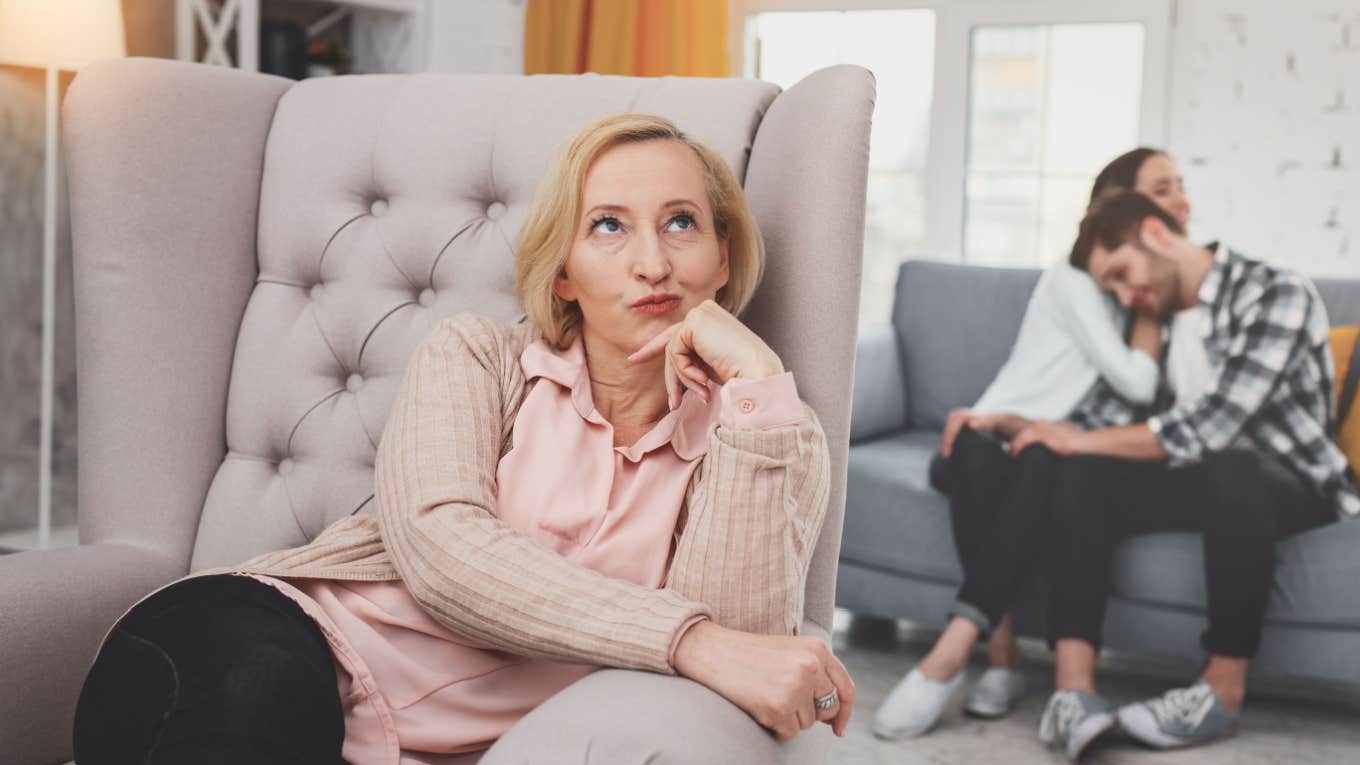 mother in law sits in armchair while son gets support from wife