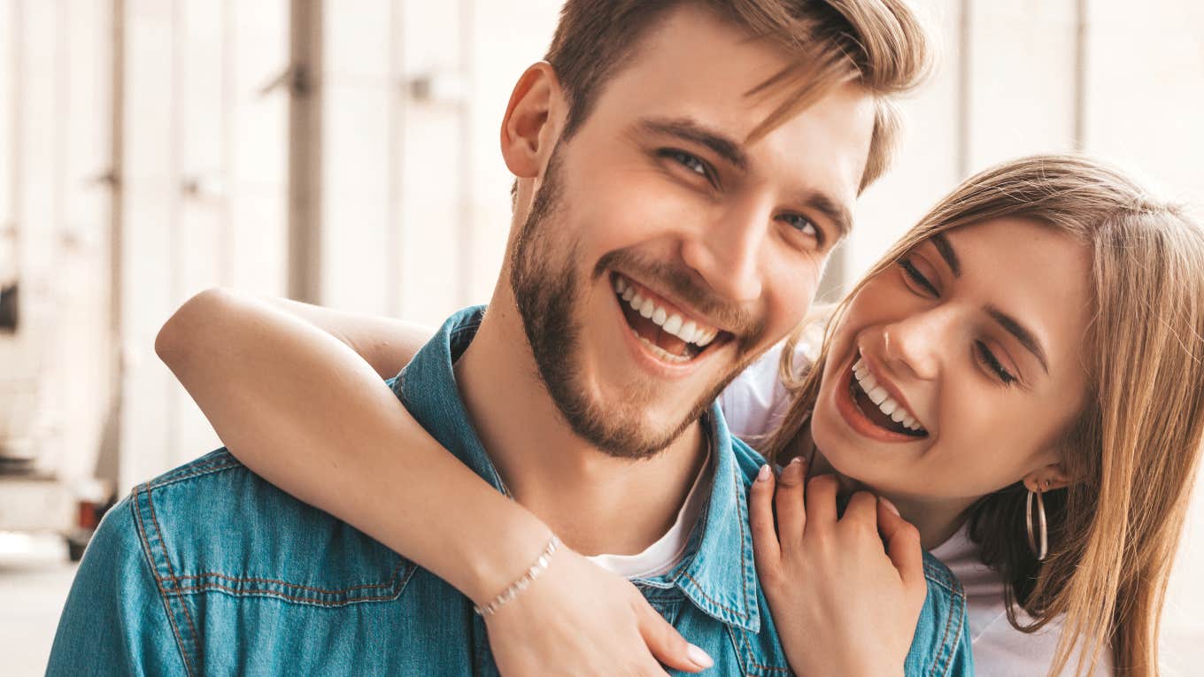 The One Thing Men Need To Accept If They Want A Lasting Relationship woman holding man from behind