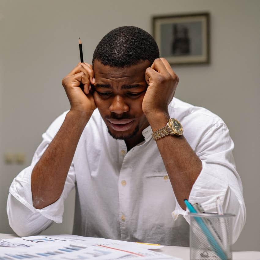 overwhelmed employee holding head in hands