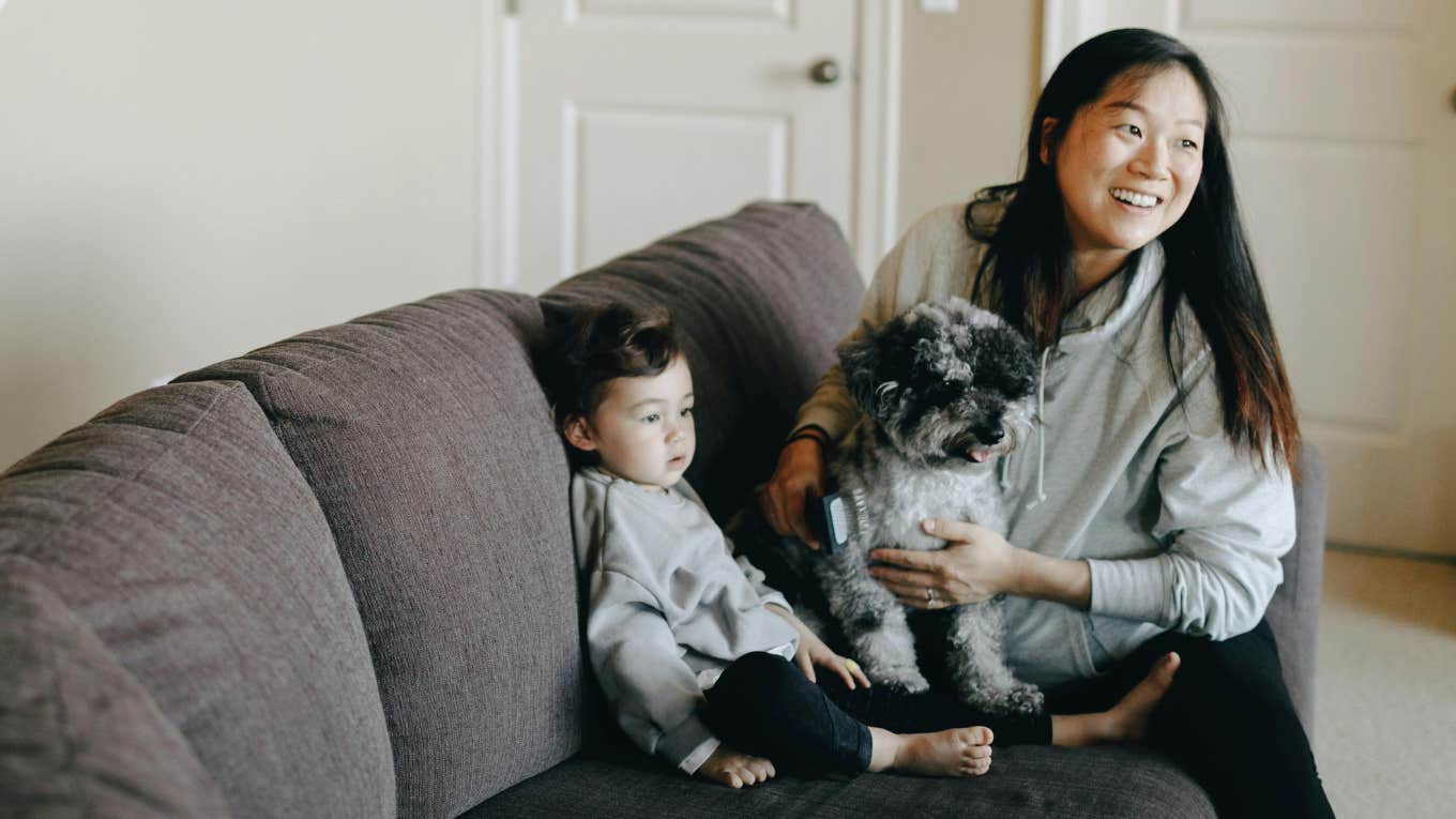 Pediatrician Tells A Mom To Get Rid Of Her Senior Dog Because Her Daughter’s Allergic A mom with her dog and toddler on a couch.