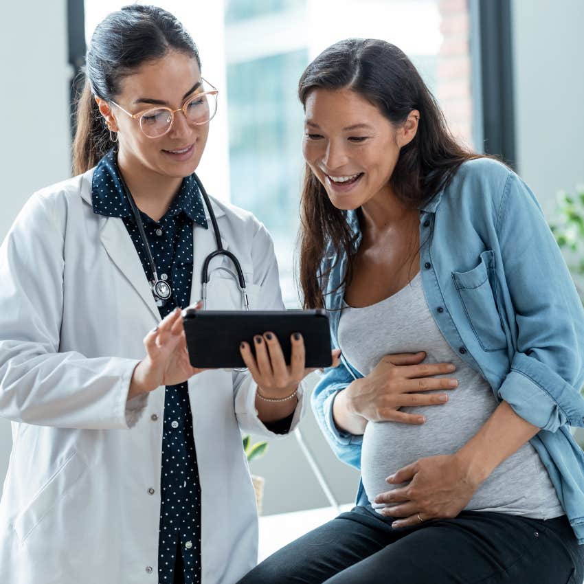 Pregnant woman sitting with her doctor. 