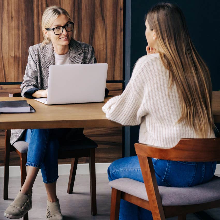 Professional woman interviewing at a desk. 