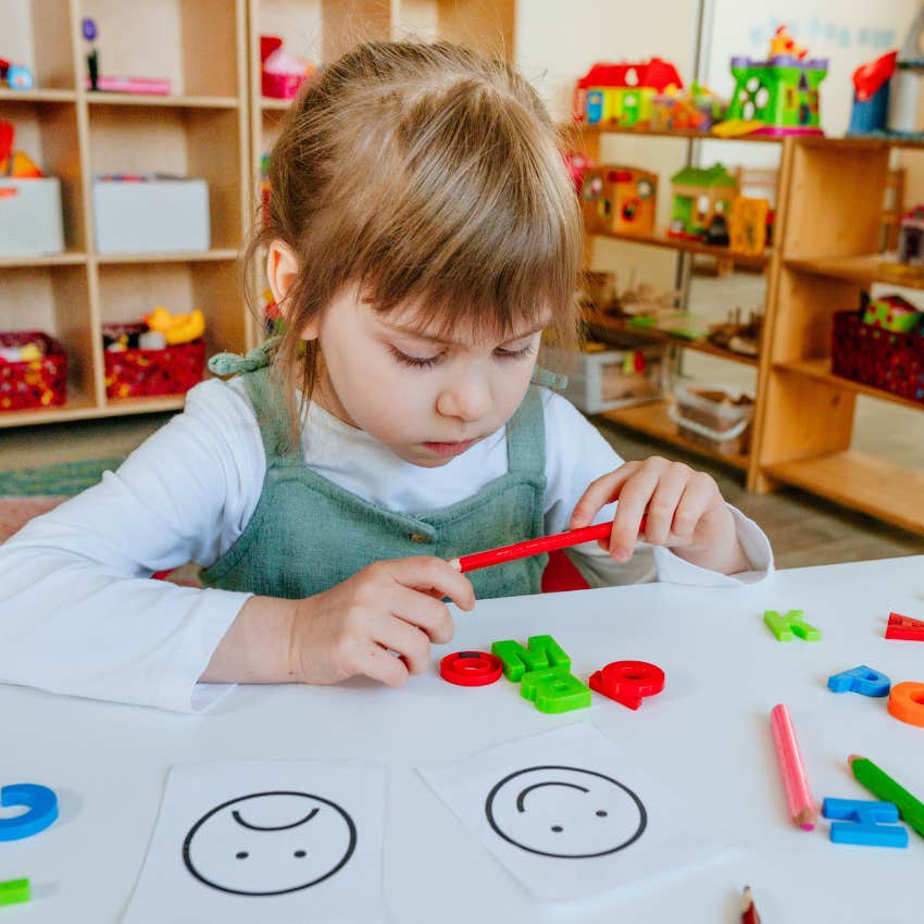 Kindergarten girl looking sad at desk. 