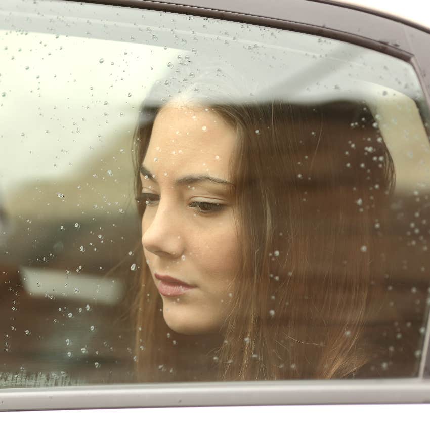 Sad woman looking out car window