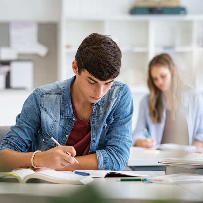  young man taking notes from books for his study