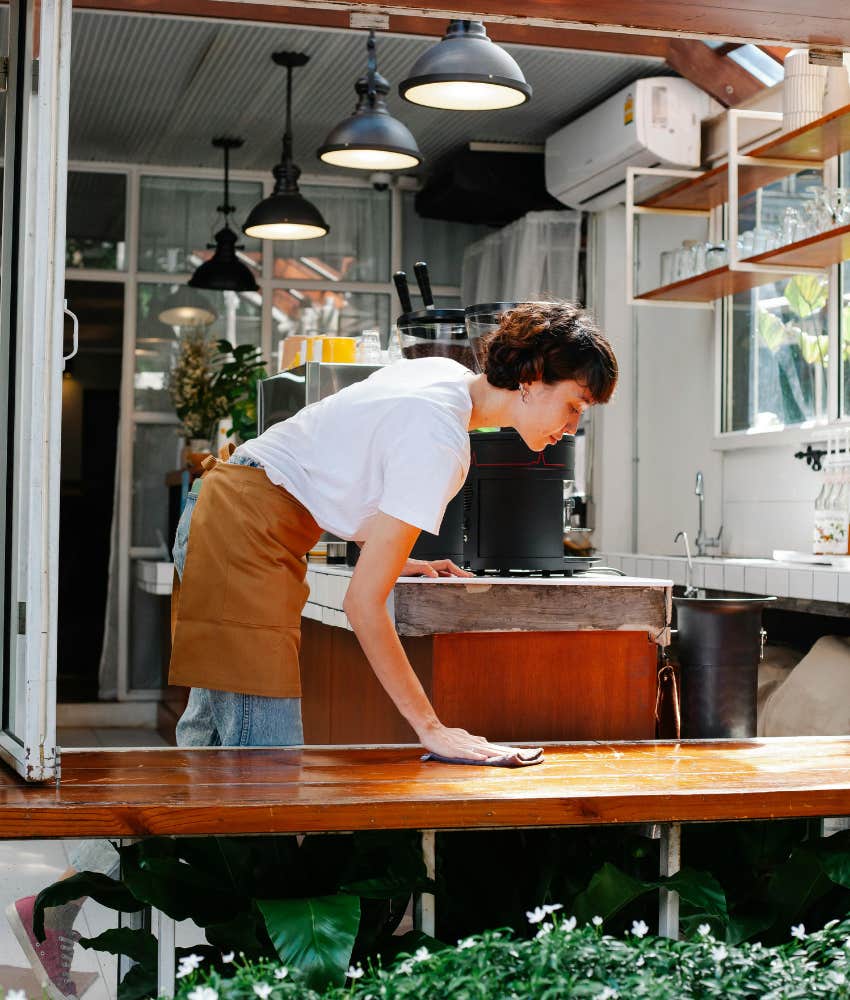 server wiping down a table