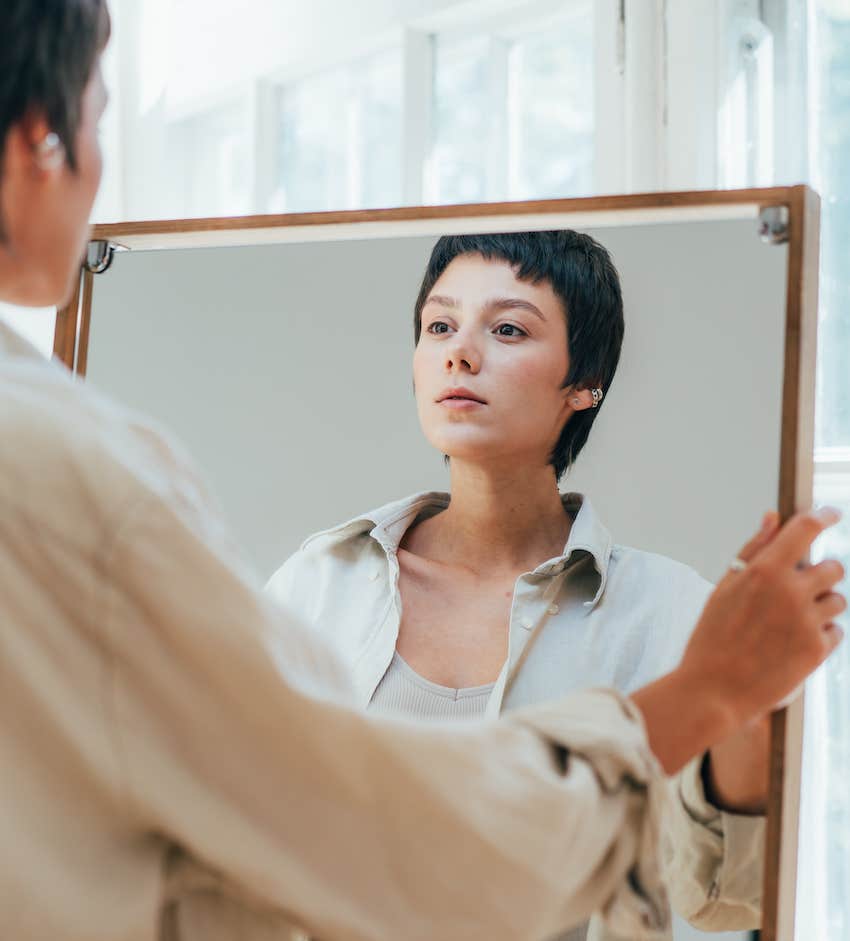 Judgmentally observing herself on a mirror