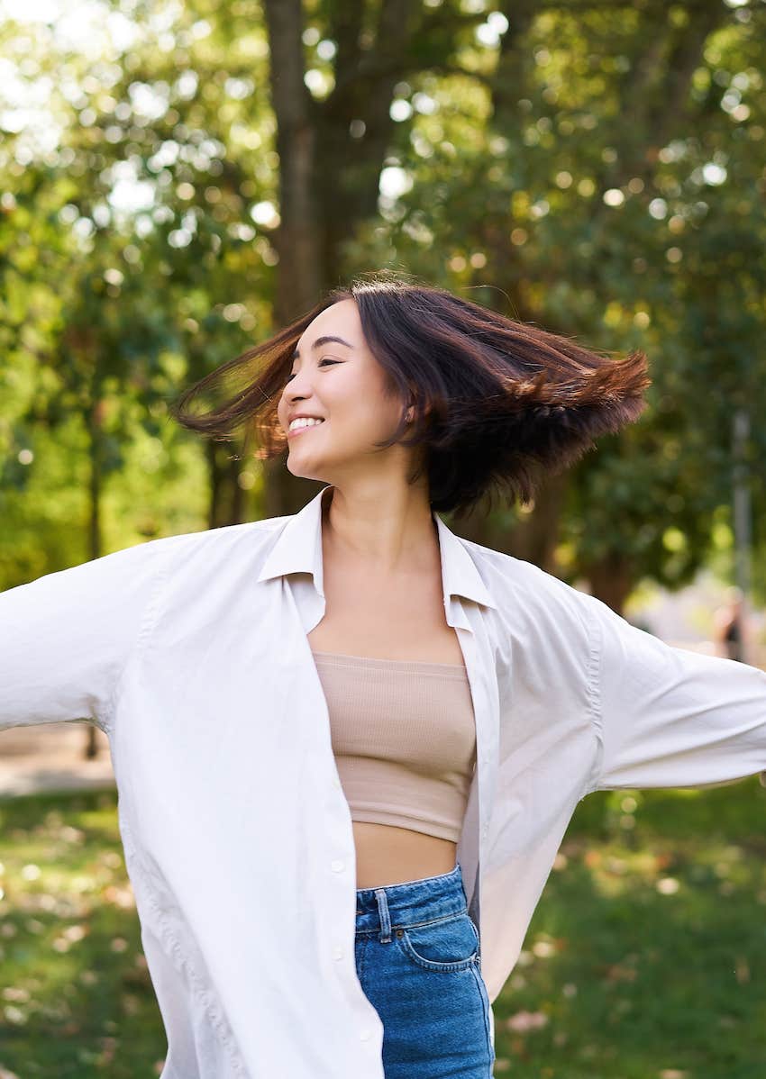 Happy woman spins in nature because her life is changing for the better