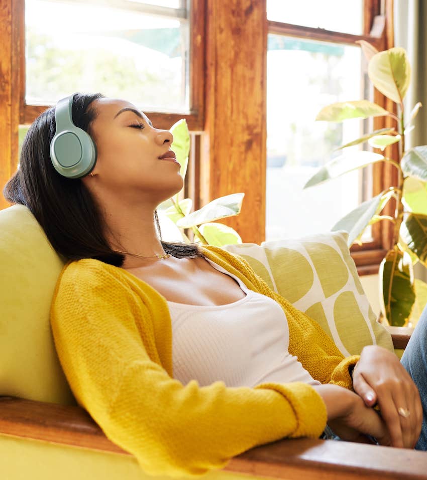 Woman relaxes with headphones on, she is sensitive