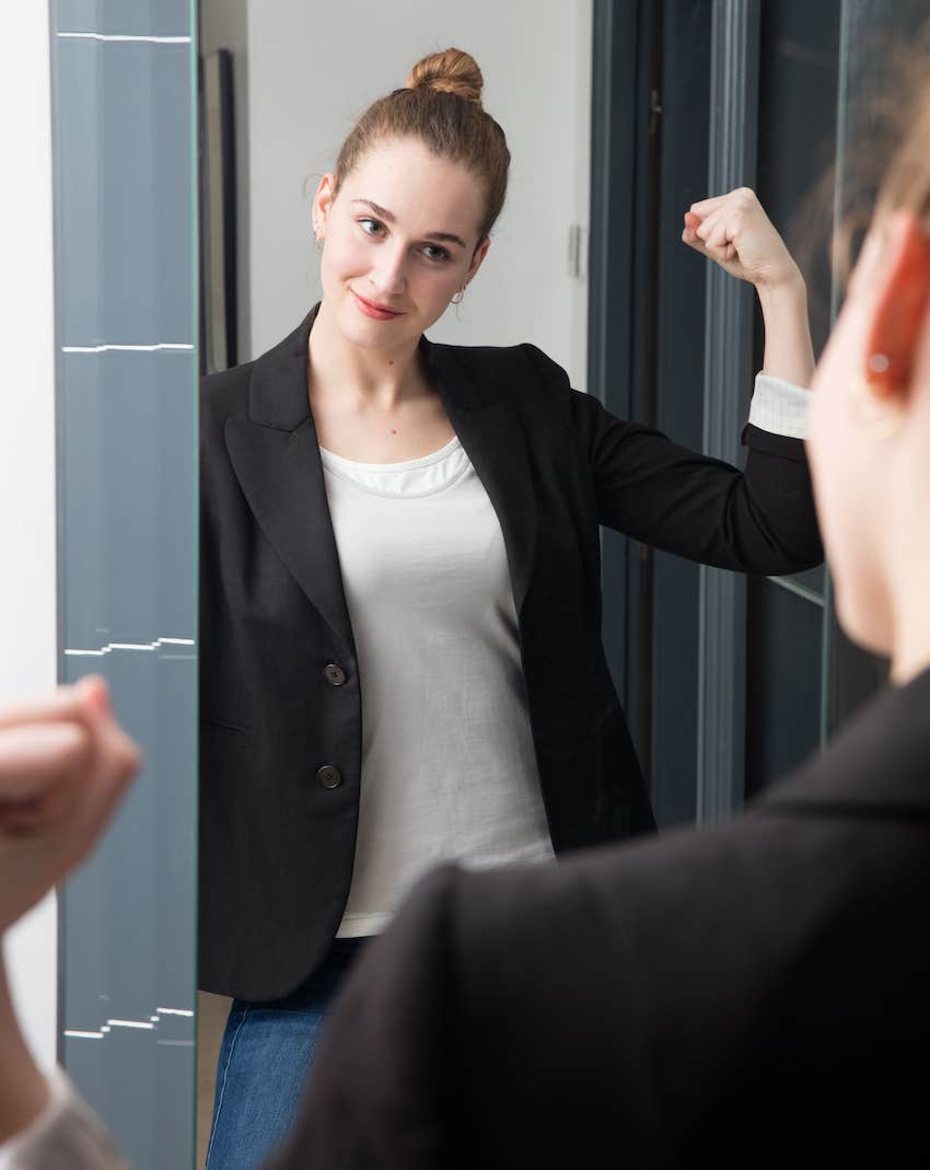 Women flexes muscles in mirror, she learned laws of love early