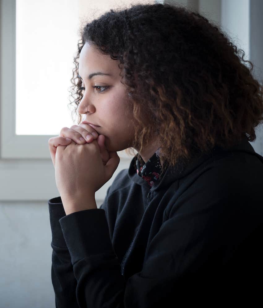 With head on hands she thinks about reasons to forgive