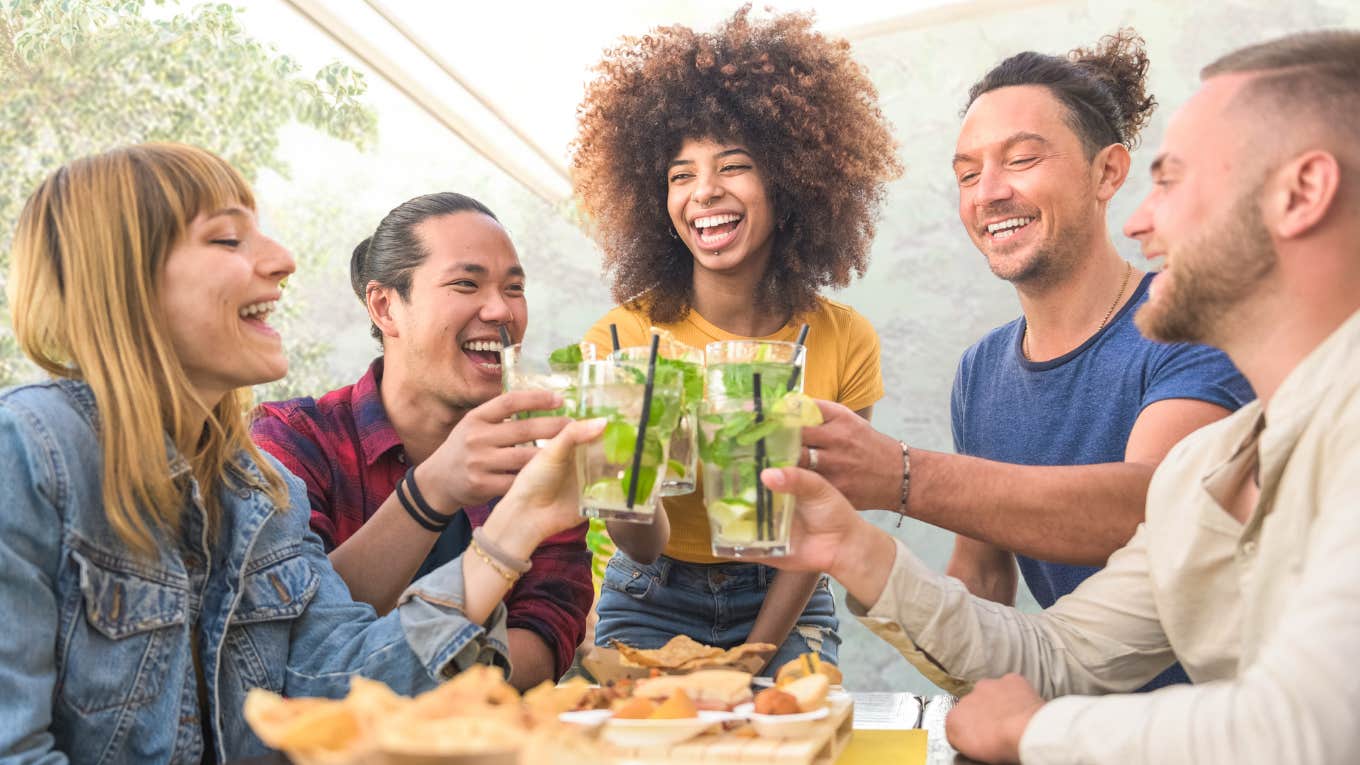 Single Woman's Friends Throw Her A Party ‘Just Because’ Friends smiling at a party together.