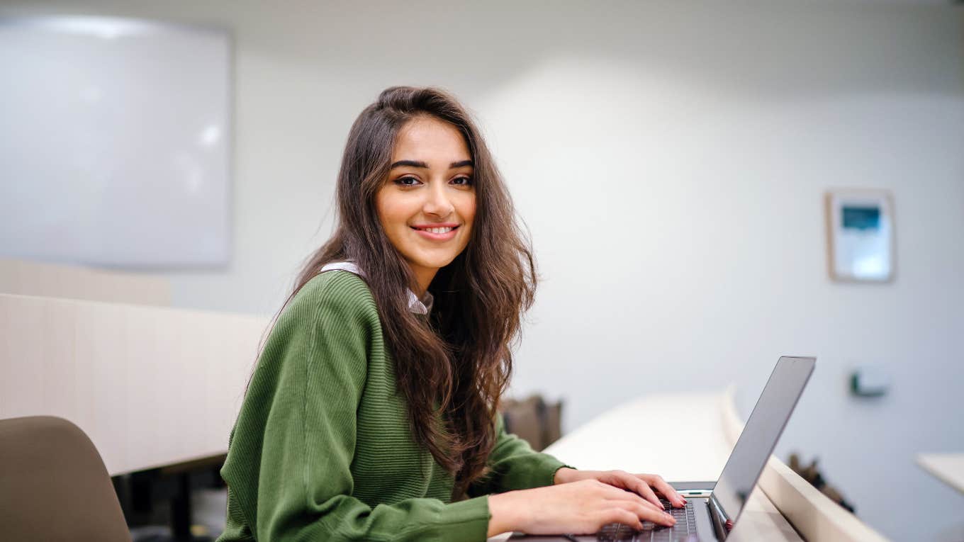 college student working on laptop in classroom