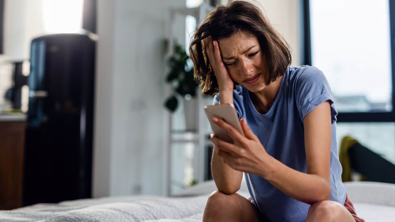 crying teen checks phone after upsetting news