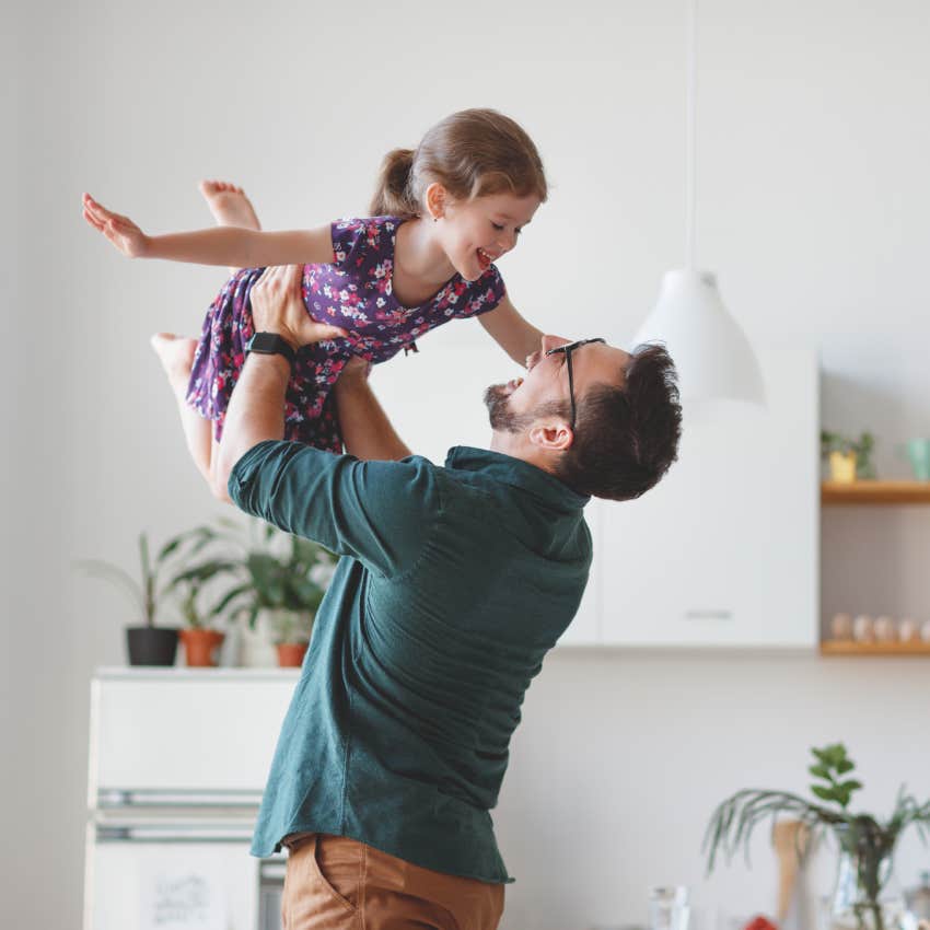 dad laughing and picking up daughter
