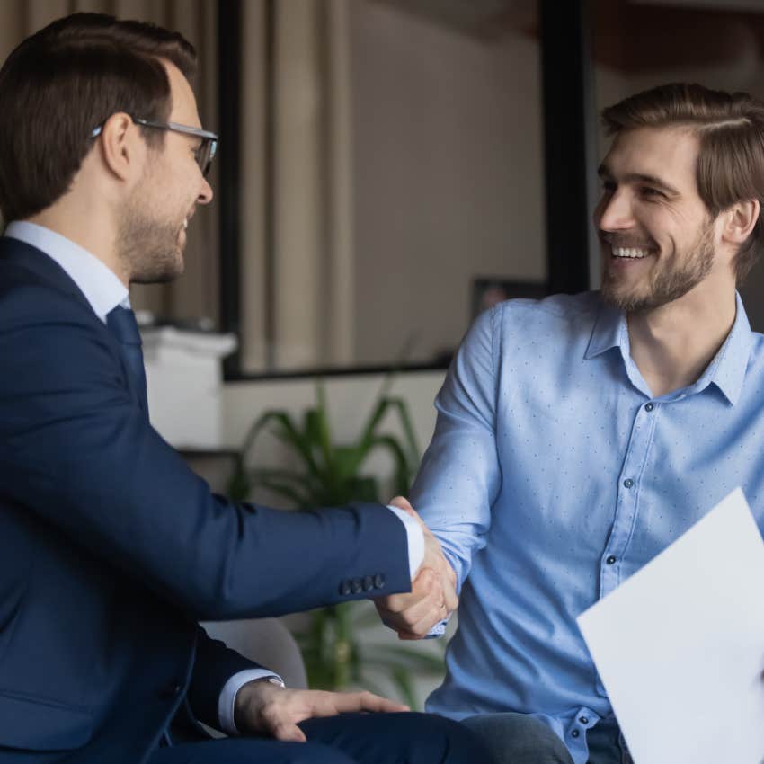 Two business partners shaking hands after signing contract