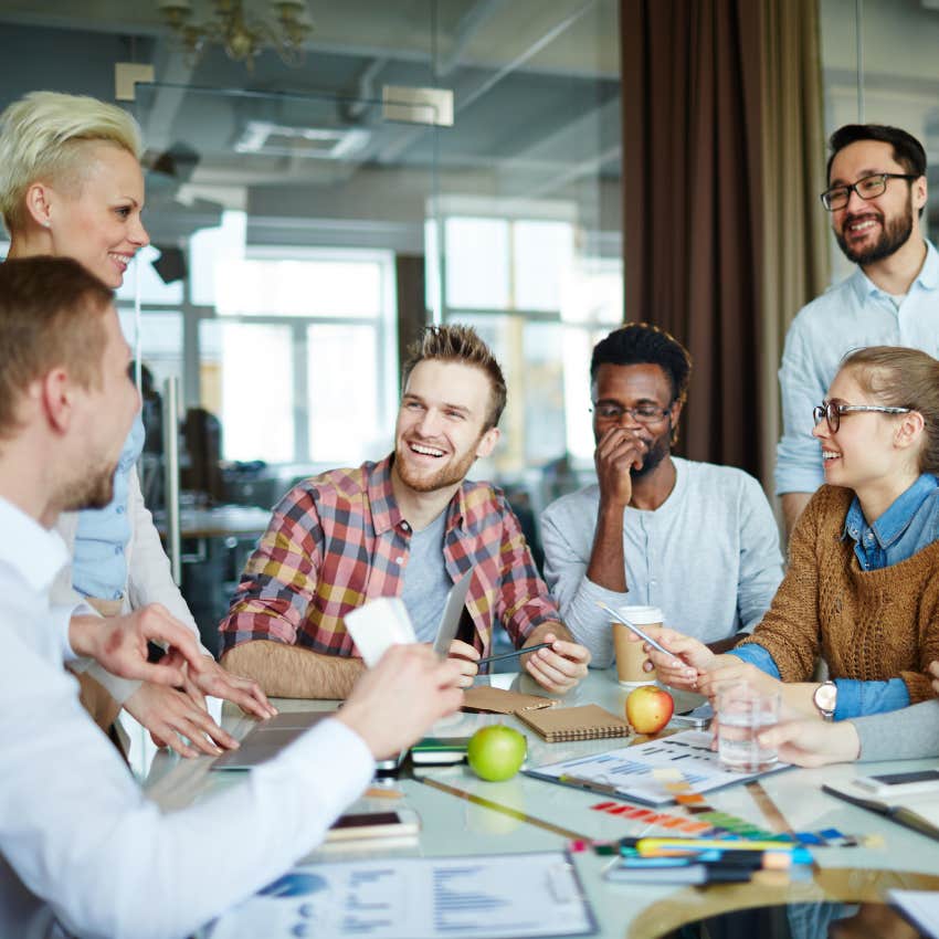 employees laughing while discussing ideas in conference room