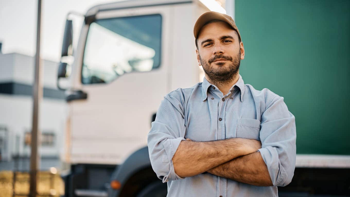 Trucker Takes His Old Job Back Just So He Can Tell His Boss He Found A Better One confident truck driver on parking lot looking at camera