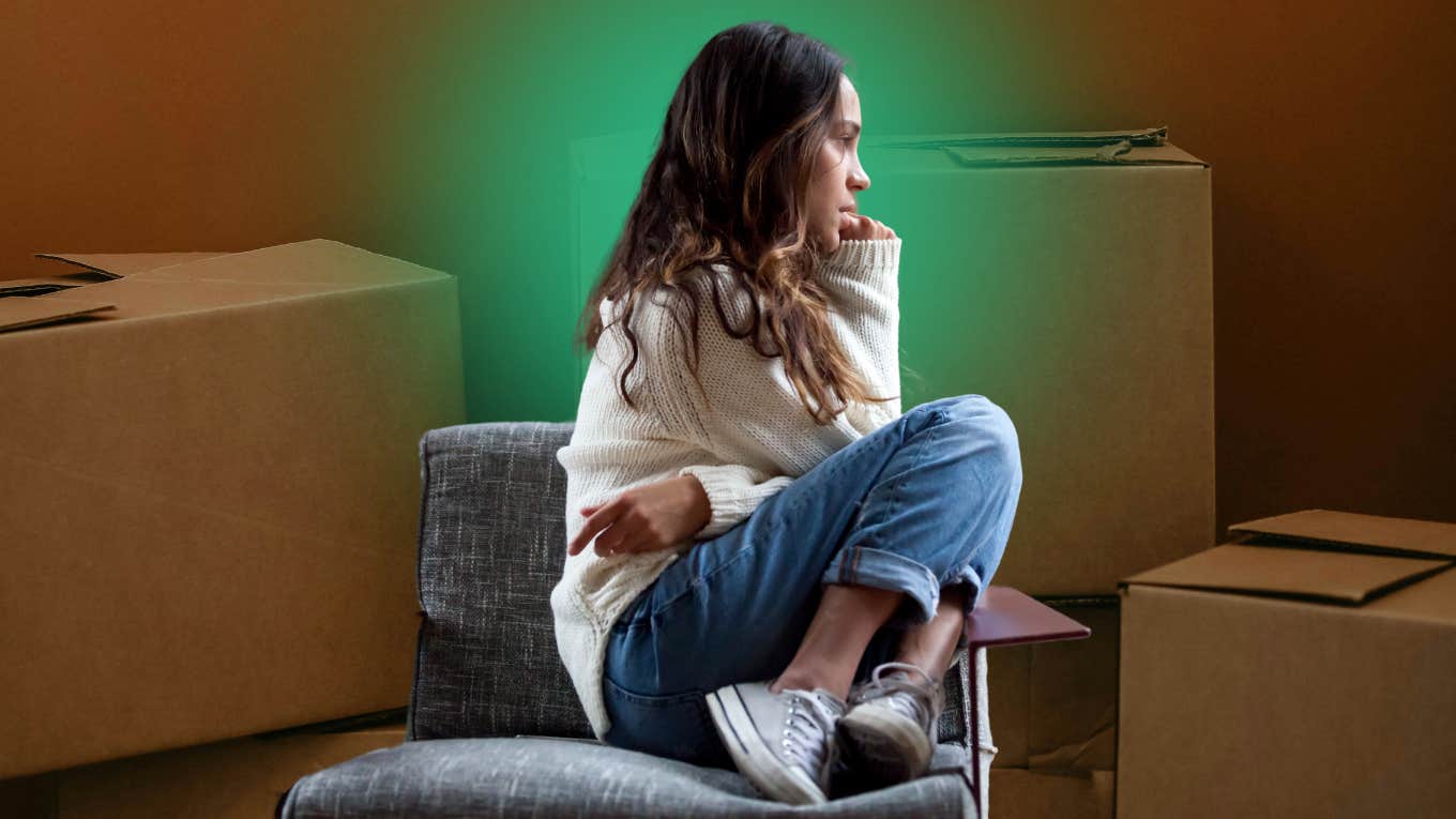 4 Ways Moving Frequently As A Kid May Have Negatively Impacted Your Wellbeing sad woman by moving boxes