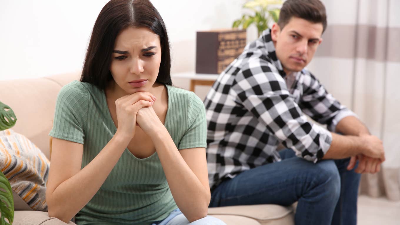 husband and wife angry with each other sitting on opposite ends of the couch