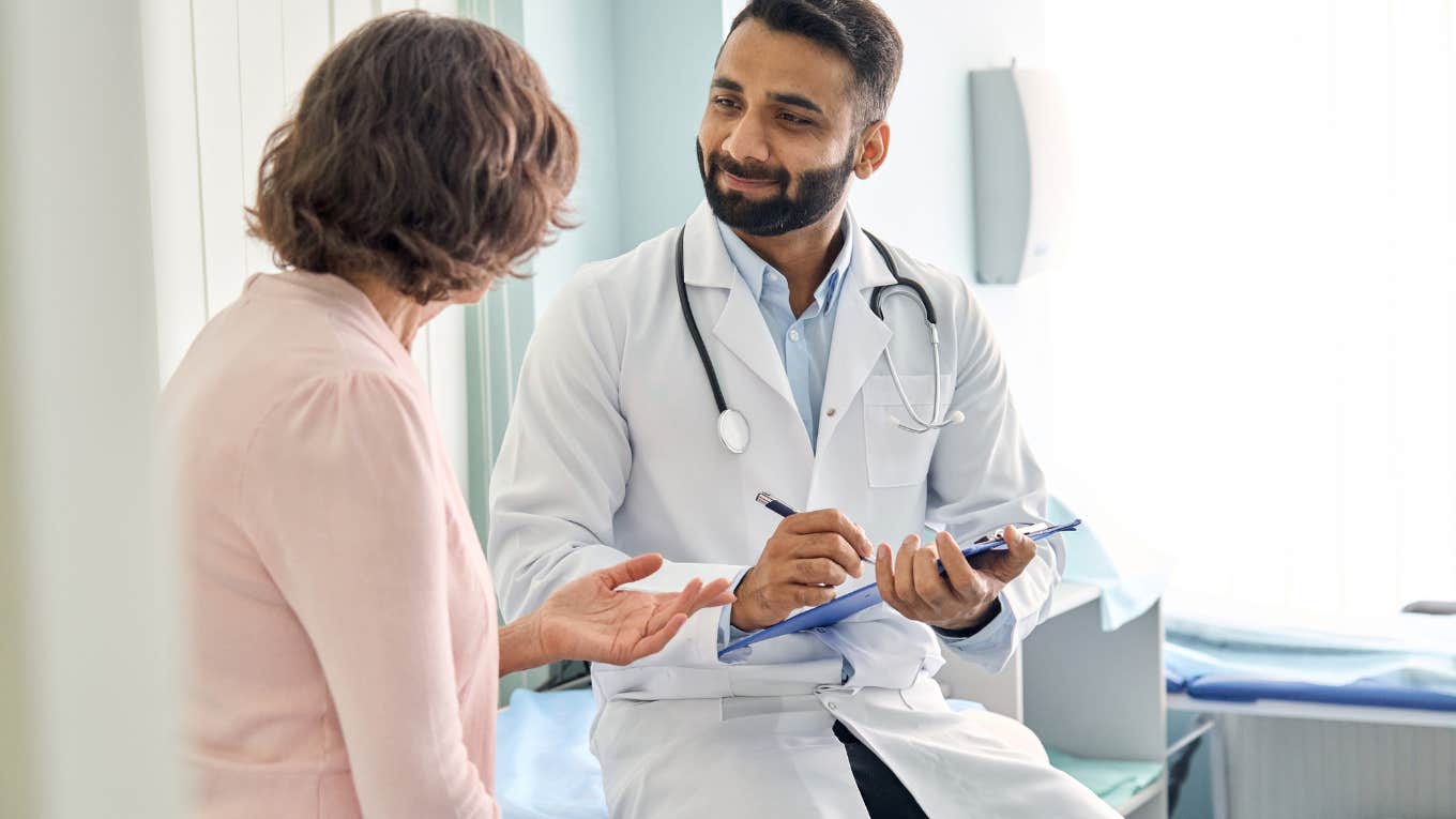 Woman Explains Why Her Doctor Was Relieved To Hear She's Moving Out Of The United States male doctor consulting patient and filling form at consultation