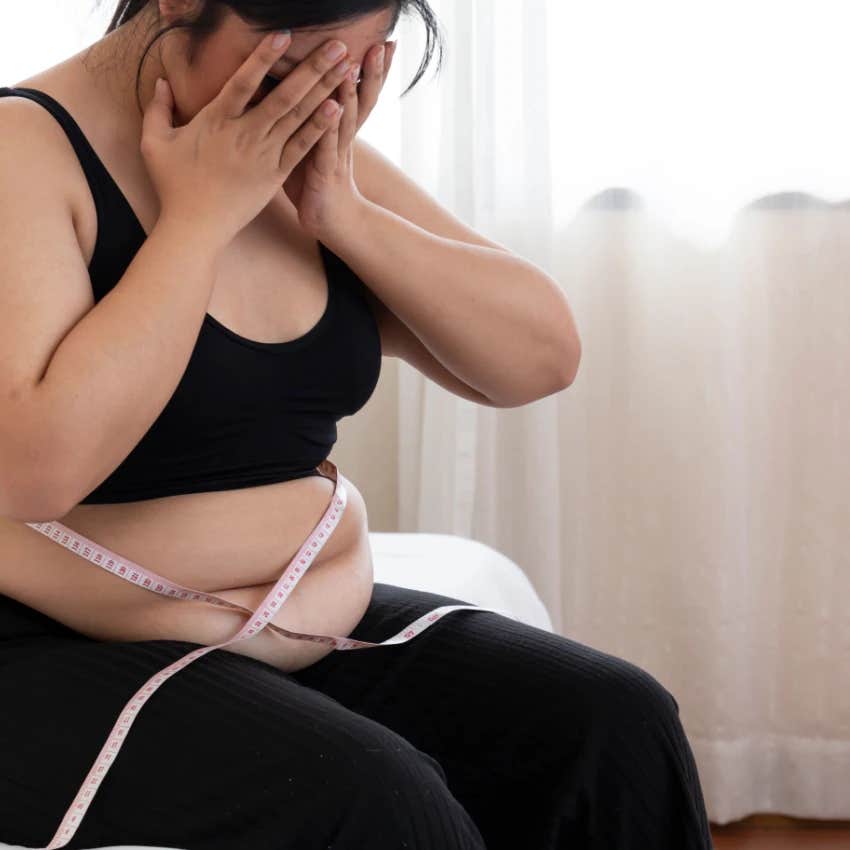 Sad woman measuring herself