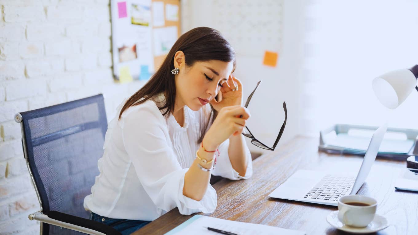 woman holding head during hard day at work