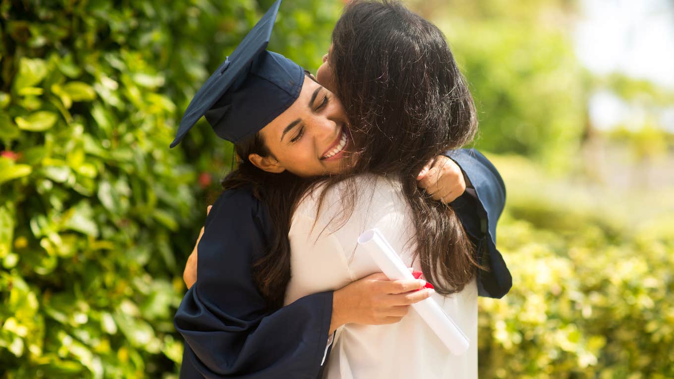 Proud mother hugging her daughter at her graduation