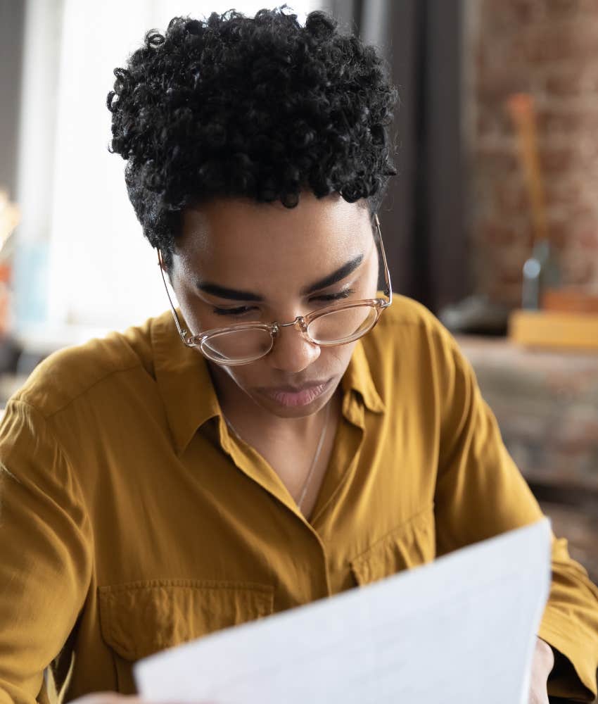 concerned woman looking at a piece of paper 