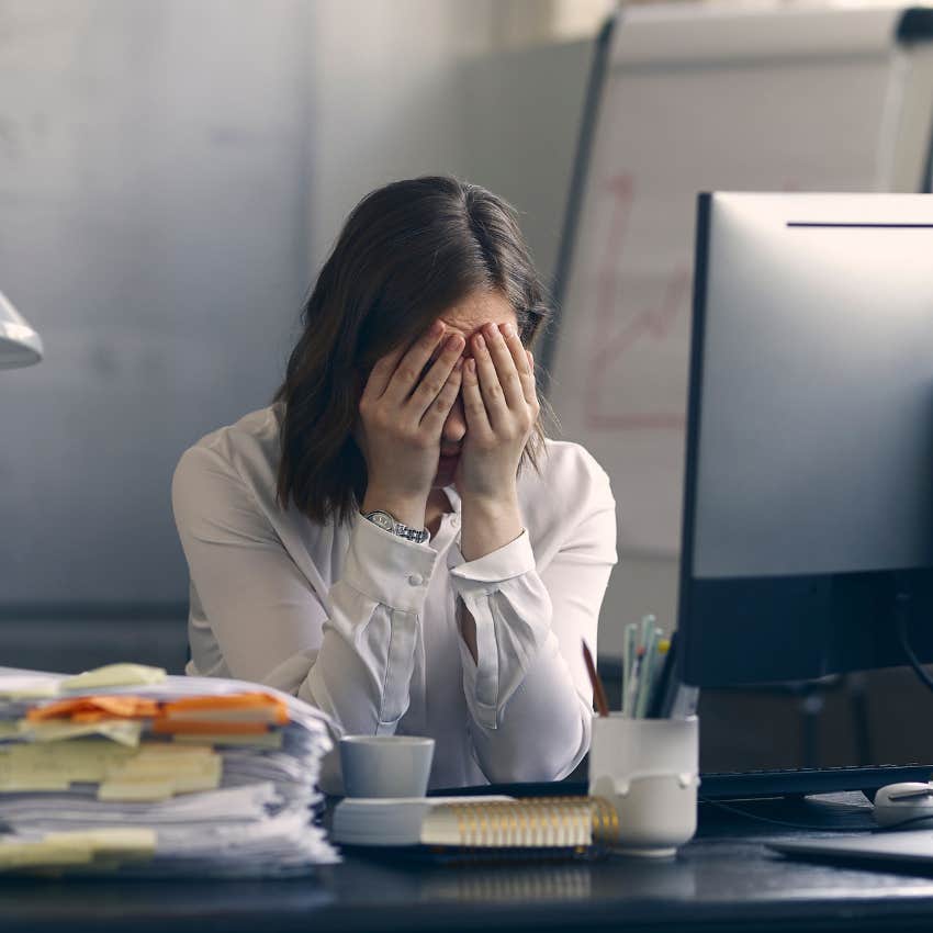 Young professional stressed with her head in her hands. 