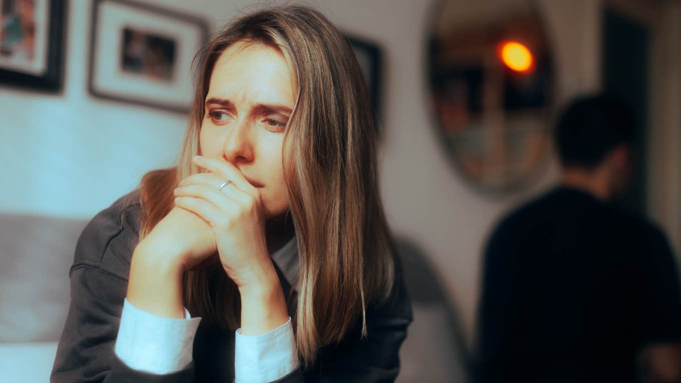 sad woman sitting on bed with husband 