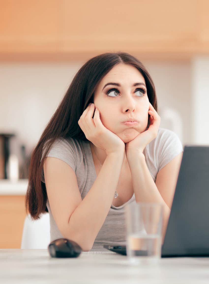 Frustrated woman at laptop filing taxes after husband's death