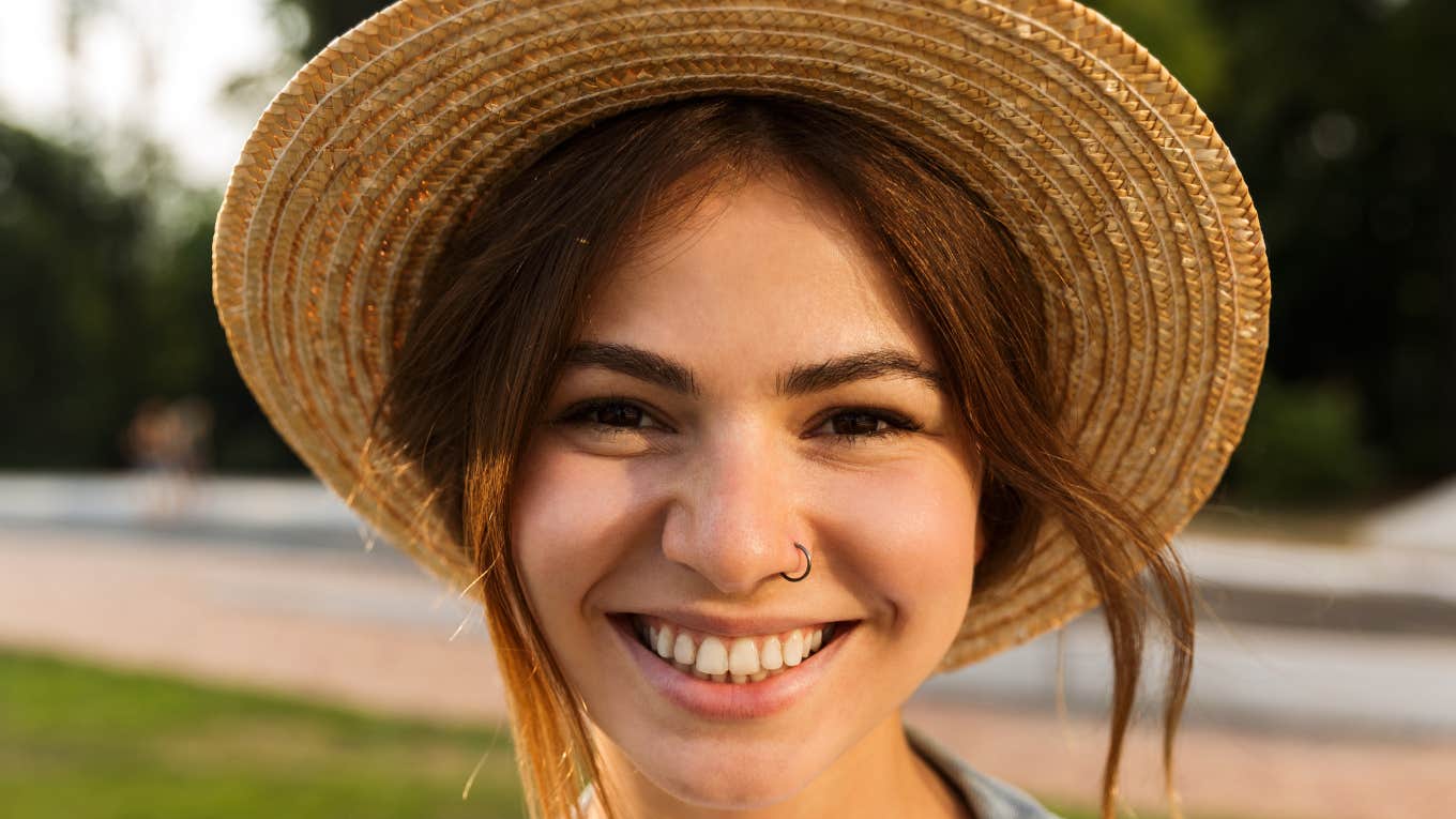 Behaviors That Make People Like You Almost Immediately smiling happy woman wearing a hat