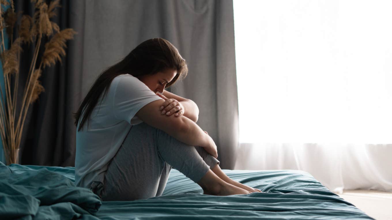 The Bravest Thing You Can Do After Being Betrayed By Someone You Loved, Respected, Or Trusted sad woman sitting on bed in bedroom with light from window