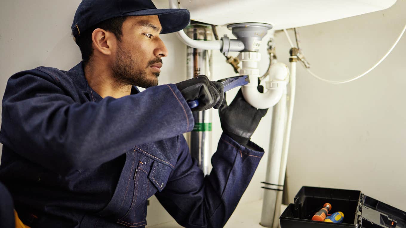 plumber working under a sink