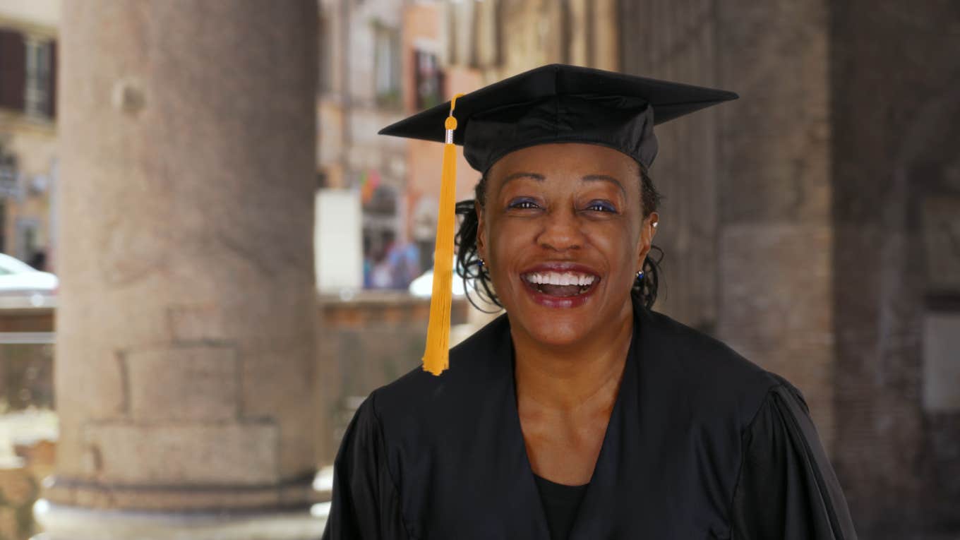 85-Year-Old Grandma Was Finally Able To Graduate High School After Earning An Honorary Diploma Portrait of senior black woman in graduation gown smiling and cheering
