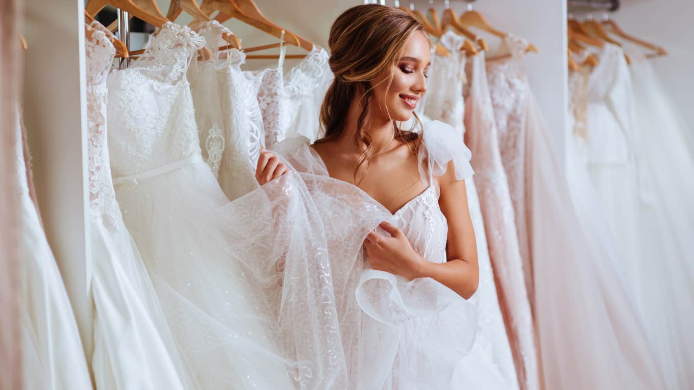 bride looking at dresses in bridal boutique