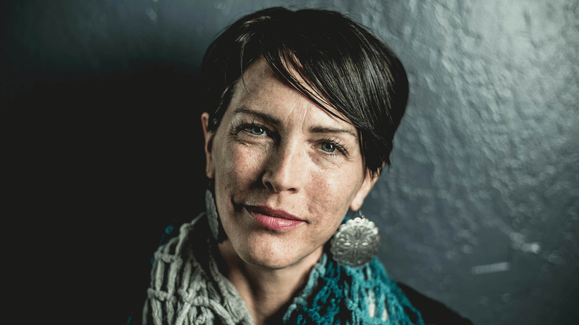 smirking woman wearing teal
