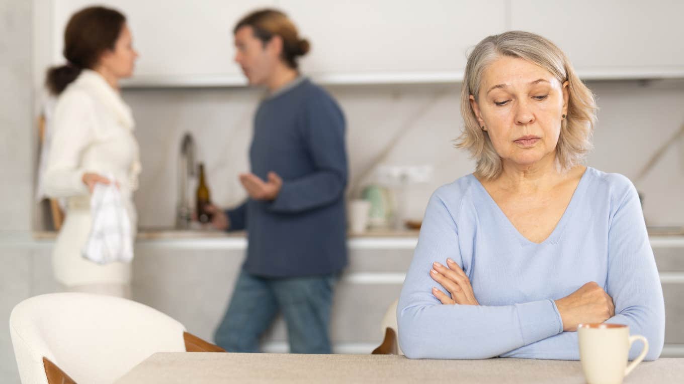 Mom Wants To Stop Paying Her Bills After Adult Son's Family Moves In Mother-in-law sitting in front of adult couple arguing about bills.