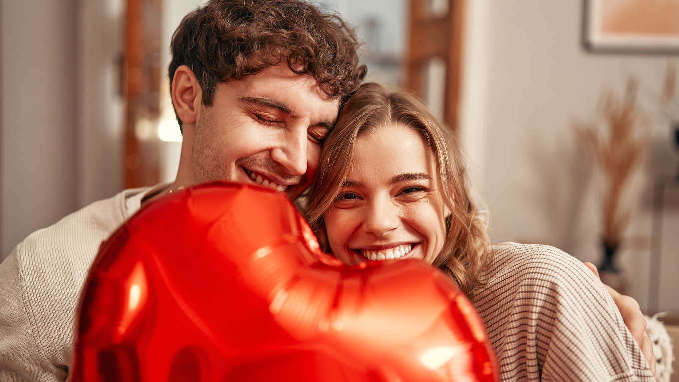 The 9 Psychological Truths About Love couple hugging each other with a heart balloon between them