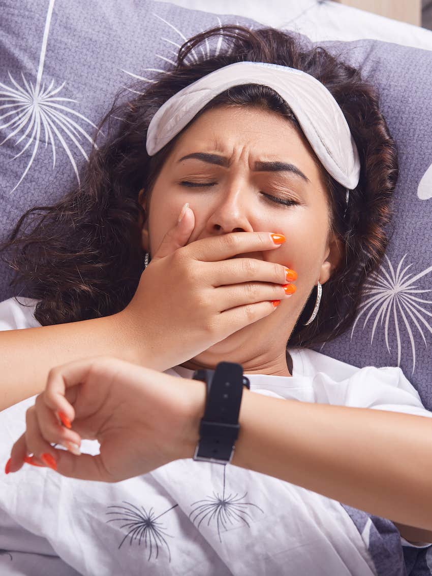 Checking her watch in bed trying to fix a sleep problem