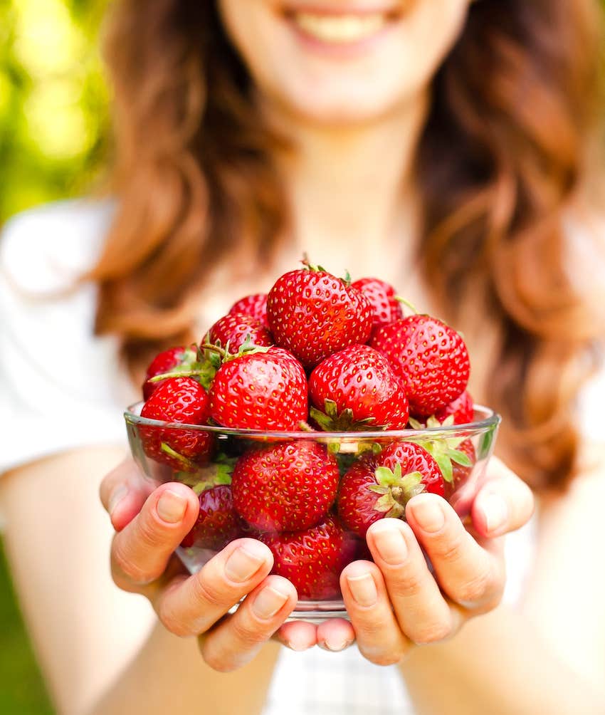 She presents a bowl of sweet strawberries