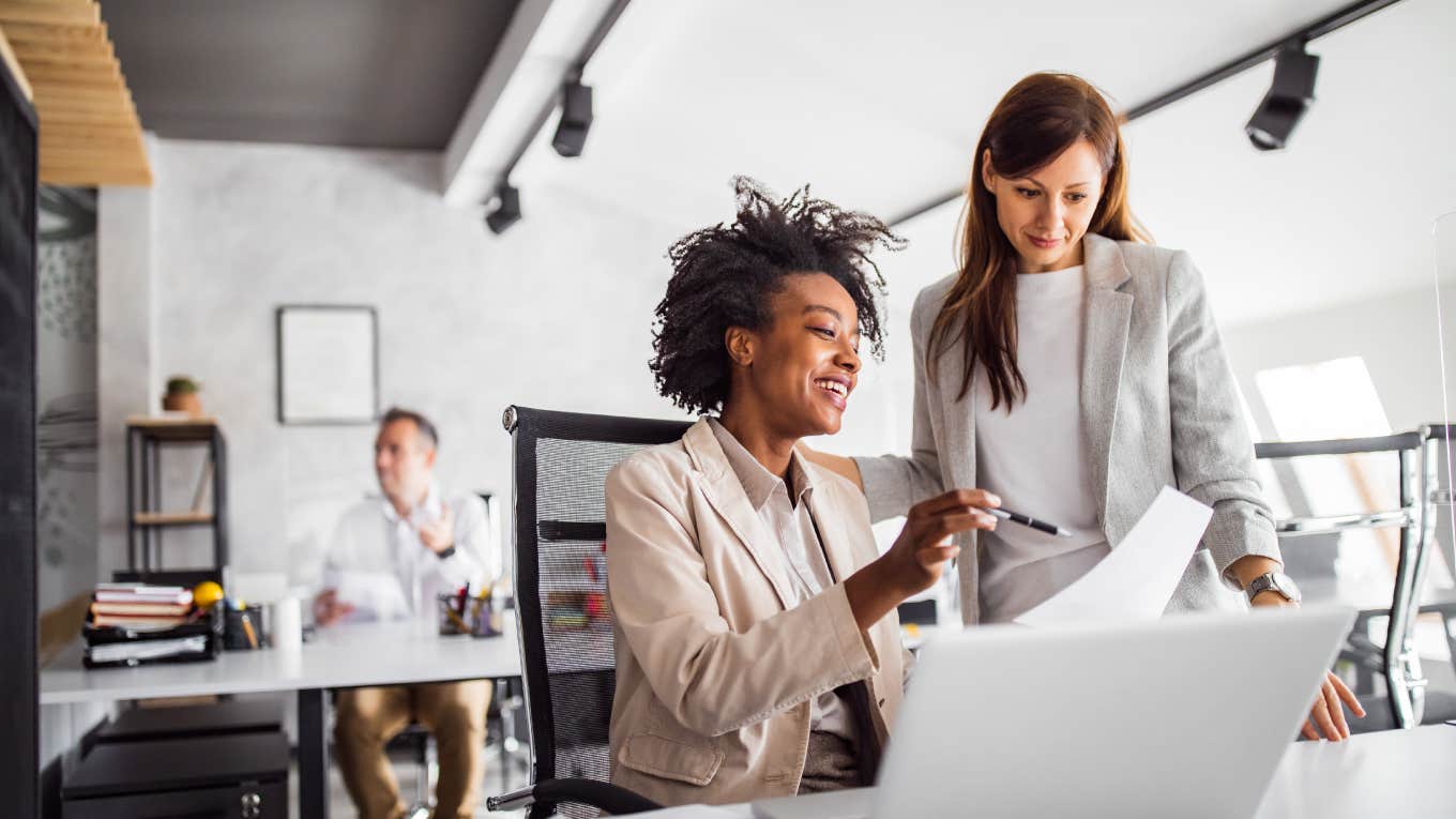 Stanford Graduate Claims Successful People Work Way More Than 40 Hours Per Week two businesswomen talking and looking at laptop in office