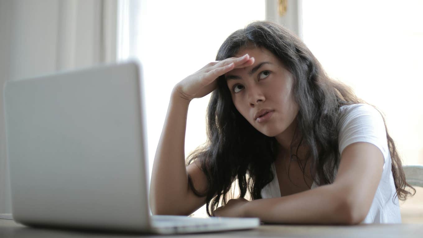 Study Reveals The One Conversation Topic At Work That Makes People Look Incompetent & Less Likable woman using laptop looking stressed