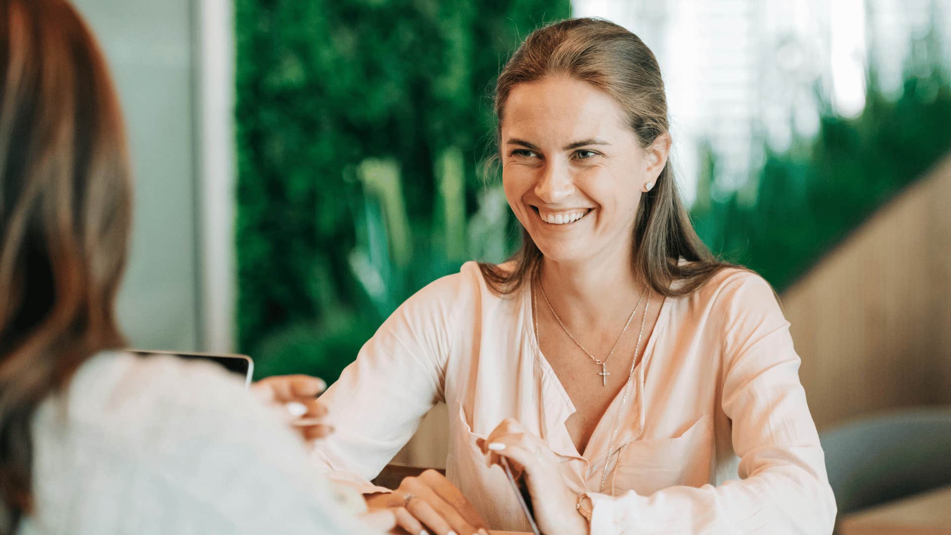 woman smiling and talking to another person