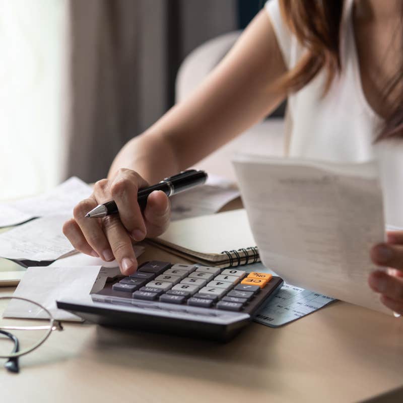 Stressed young woman calculating monthly home expenses