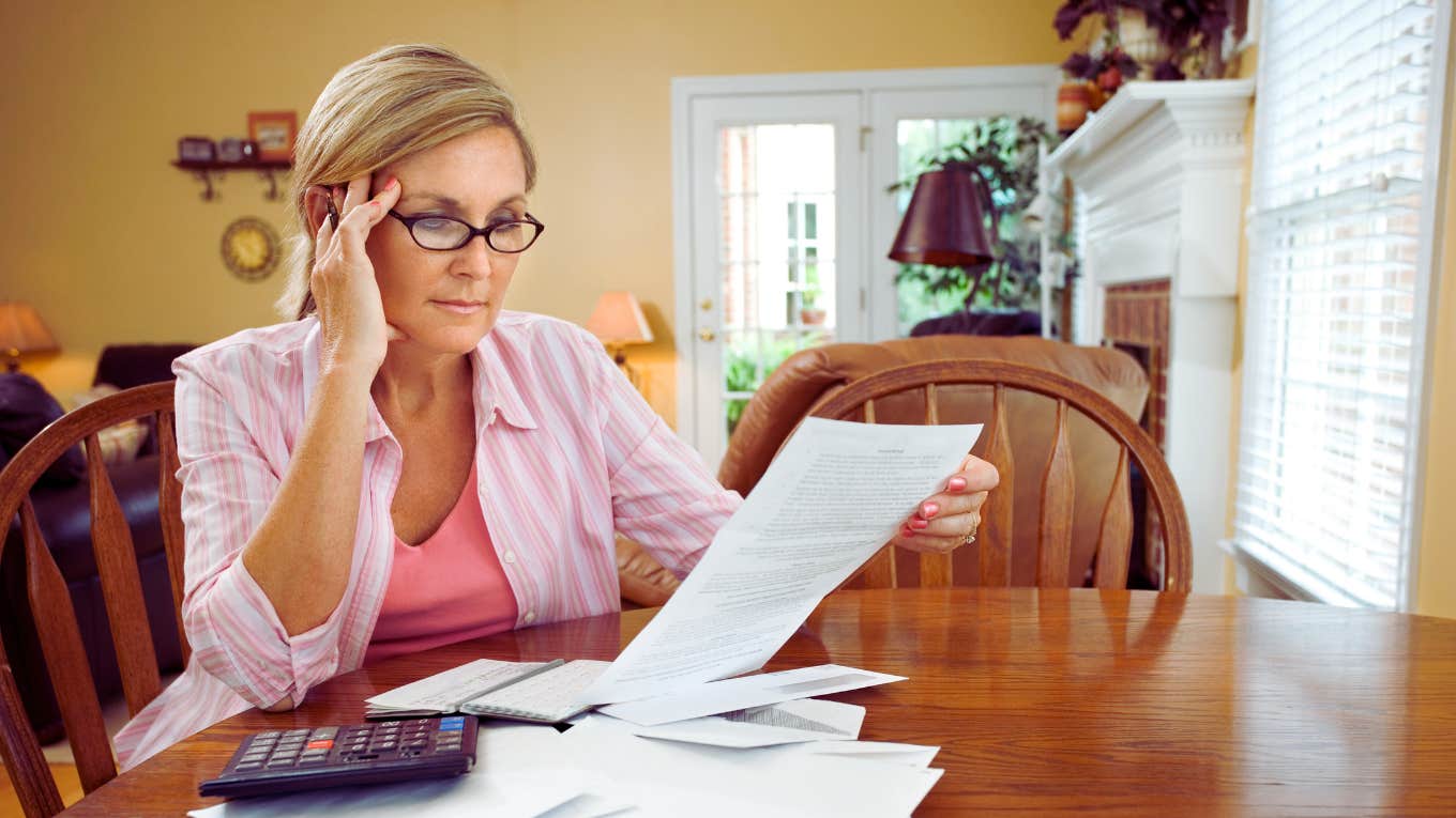 Woman Refused To Pay Her Bills And Her Credit Score Went Up woman sitting at table paying monthly bills