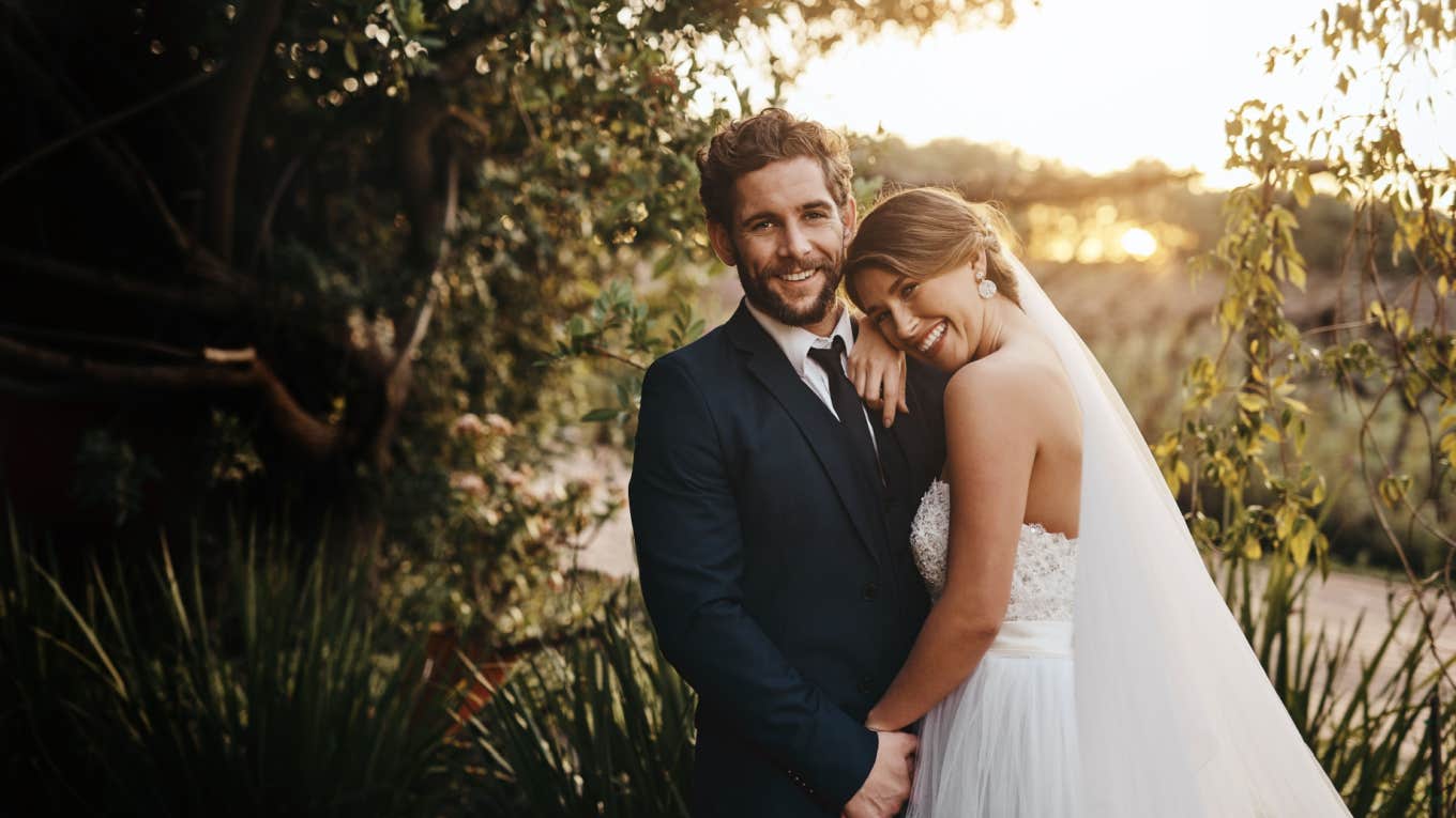 Newlywed Reveals Why Couples Who Wait A Long Time To Get Married Are Doing It Right bride and groom smile and pose together outside during wedding