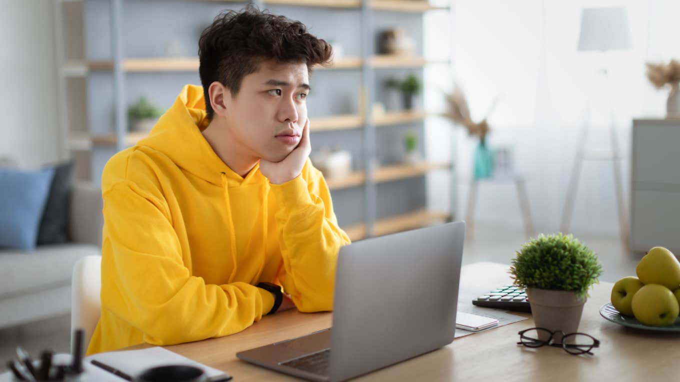 Wealthy 19-Year-Old Who Doesn't Ever Need To Work Wonders What A 'Rich Kid Should Do With Their Life' bored teenager sits at desk in front of laptop wondering what to do
